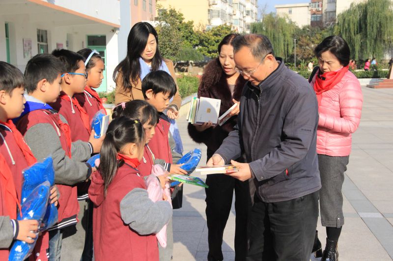 05连云支部活动中，原市委会副主委史志伟（前排）、党员吕峻（后排左一）、章莉（后排中间）、孙庆琪（后排右一）向南巷小学贫困学生分发捐赠的衣物和图书.JPG